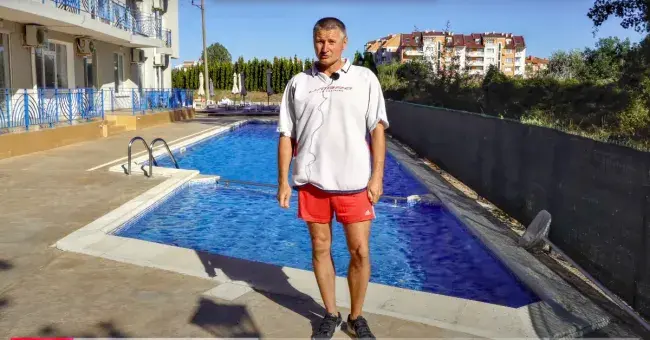 mężczyzna na tle basenu i kompleksu