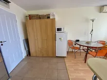 szafa na ubrania, lodówka, mikrofala, stolik z krzesłami
