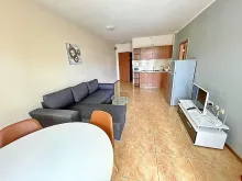 sofa narożna, stolik z krzesłami, lodówka