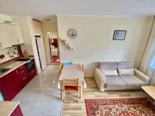sofa rozkładana, aneks kuchenny, stół obiadowy, krzesła