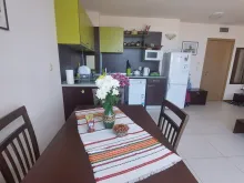 stół z krzesłami, aneks kuchenny, lodówka, ława