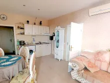Sofa, stół z krzesłami, lodówka, aneks Kuchenny