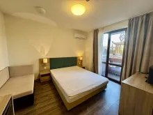 Łóżko i sofa, wyjście na balkon.