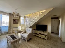 widok na salon i schody prowadzące na drugi poziom apartamentu