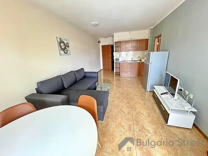 sofa narożna, stolik z krzesłami, lodówka