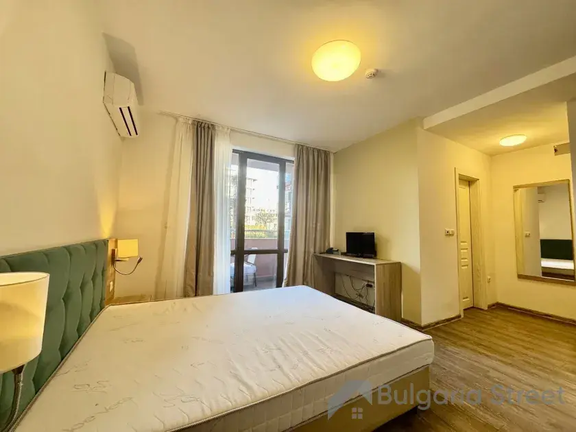 Łóżko i wyjście na balkon.