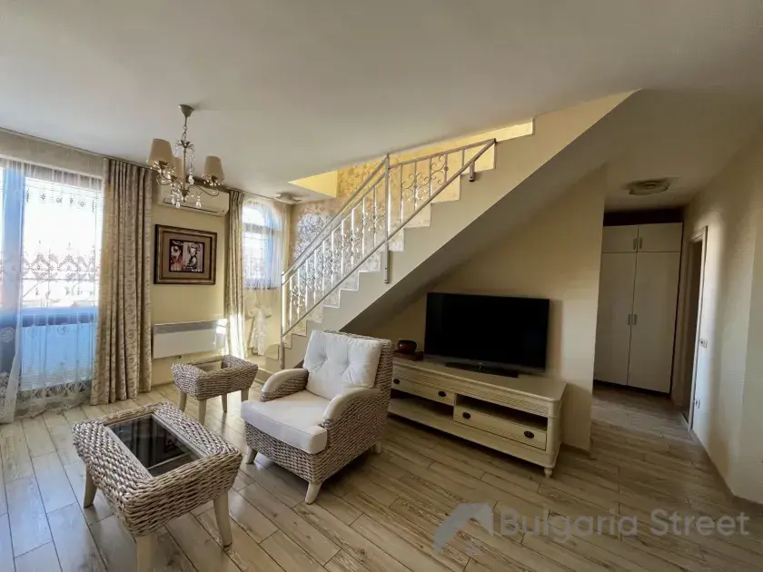 widok na salon i schody prowadzące na drugi poziom apartamentu